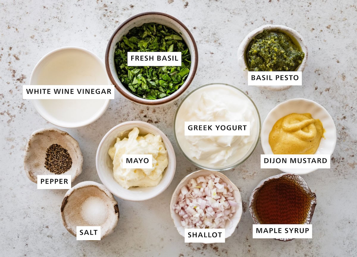 Ingredients measured out for green goddess dressing: fresh basil, basil pesto, greek yogurt, dijon mustard, maple syrup, shallot, mayo, salt, pepper, and white wine vinegar.