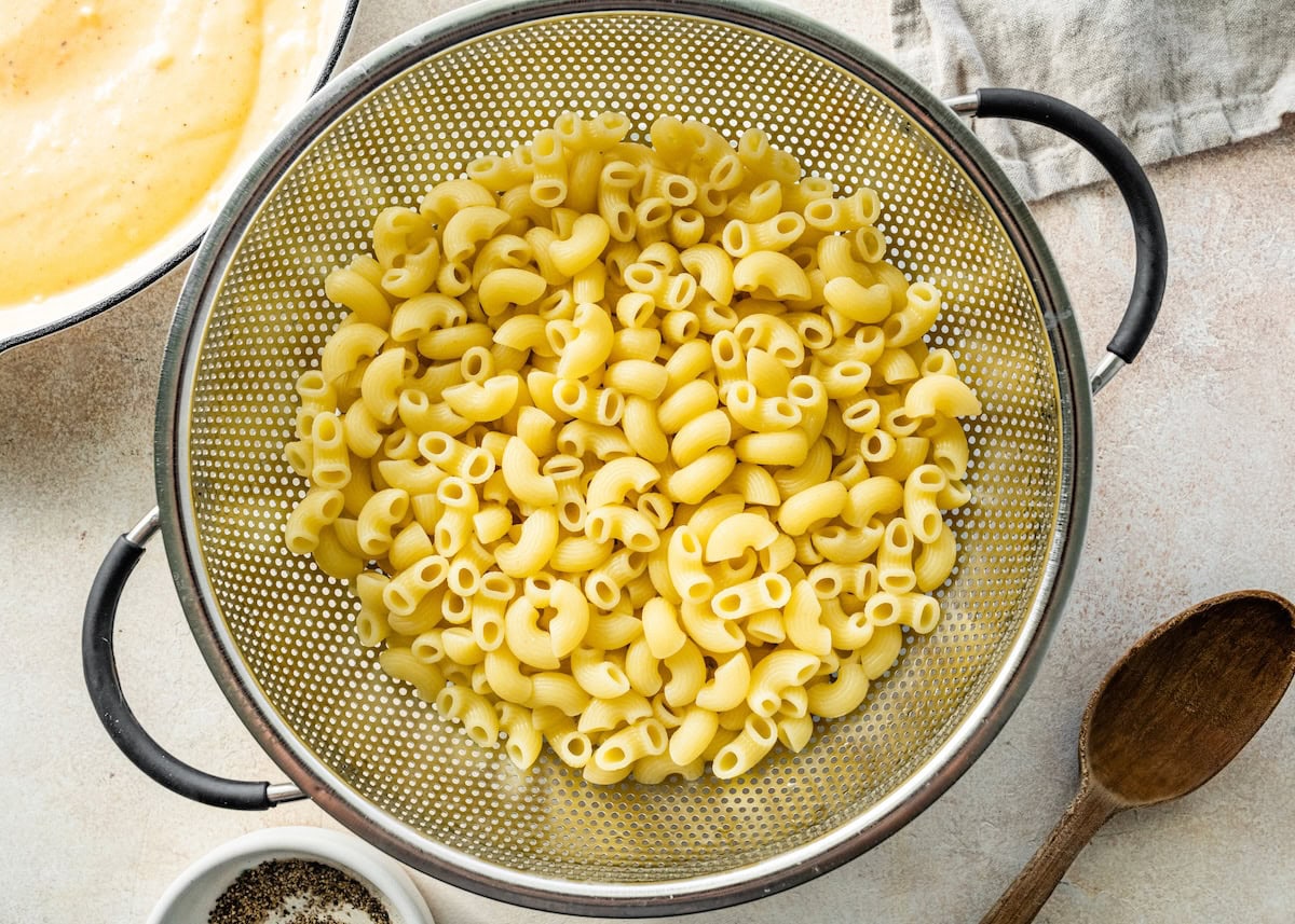 Macaroni noodles in a metal colander.